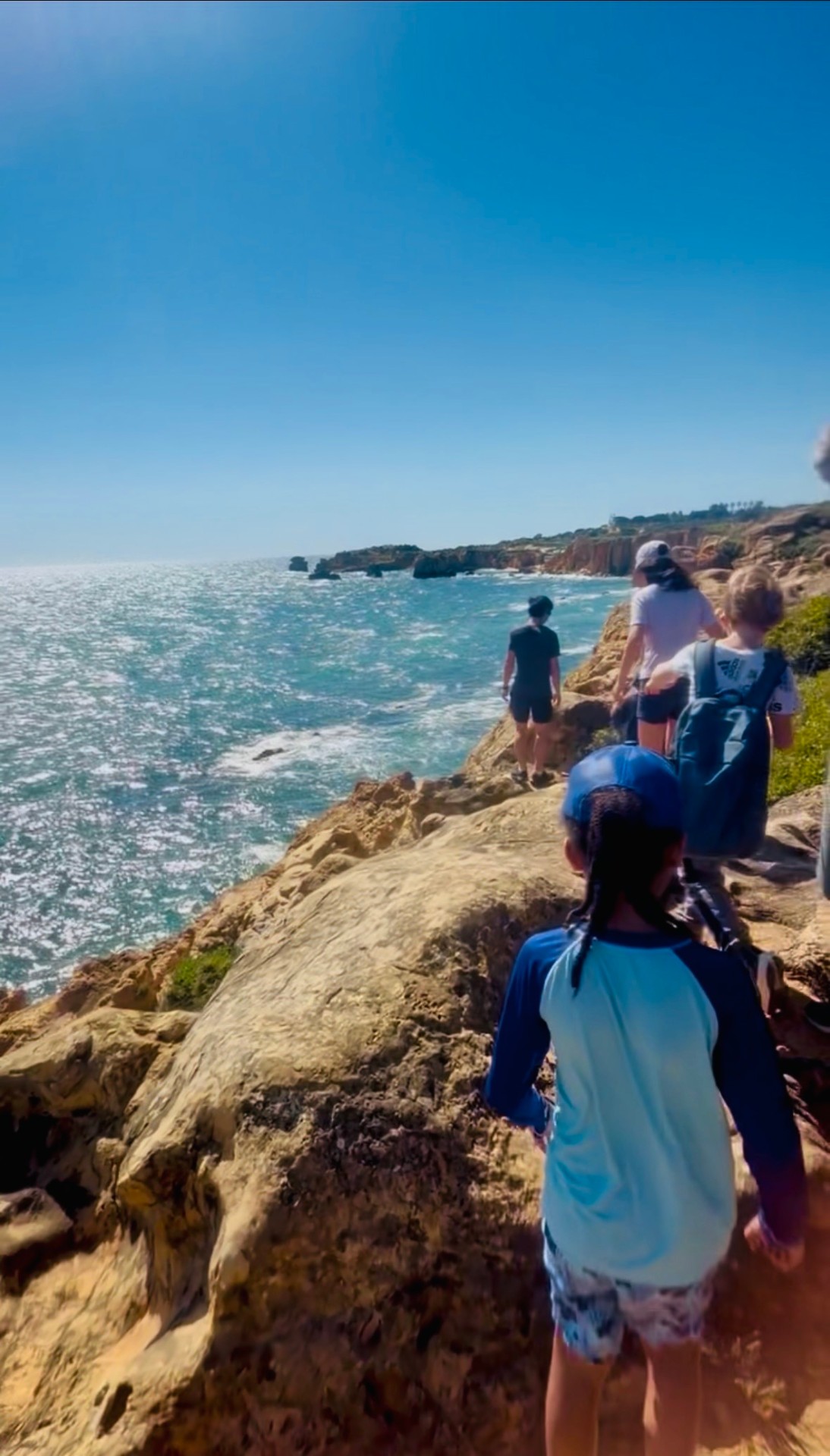 Family hiking along ocean cliffs in Portugal