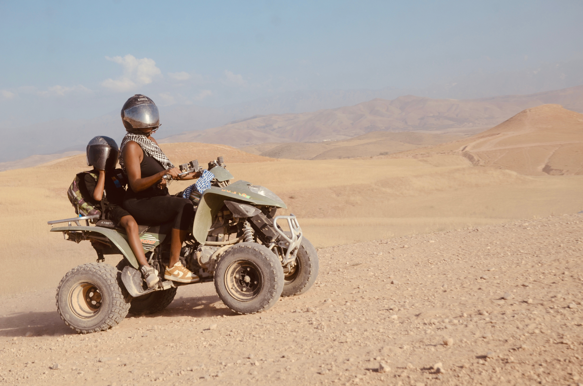 Amber and her son riding an ATV through the Agafay Desert